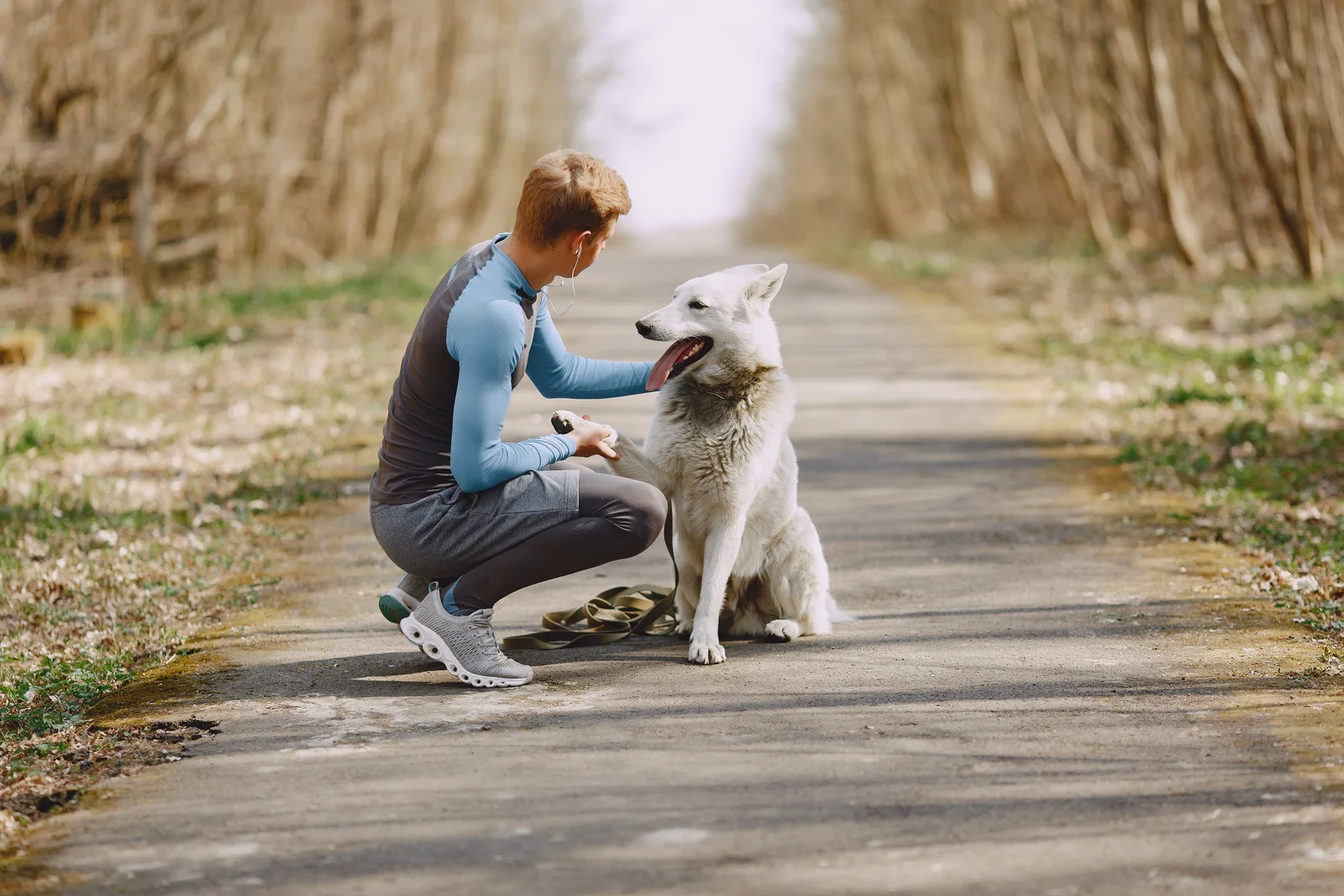 Ploegmedewerker ontspant met haar hond op een boswandeling na de dienst