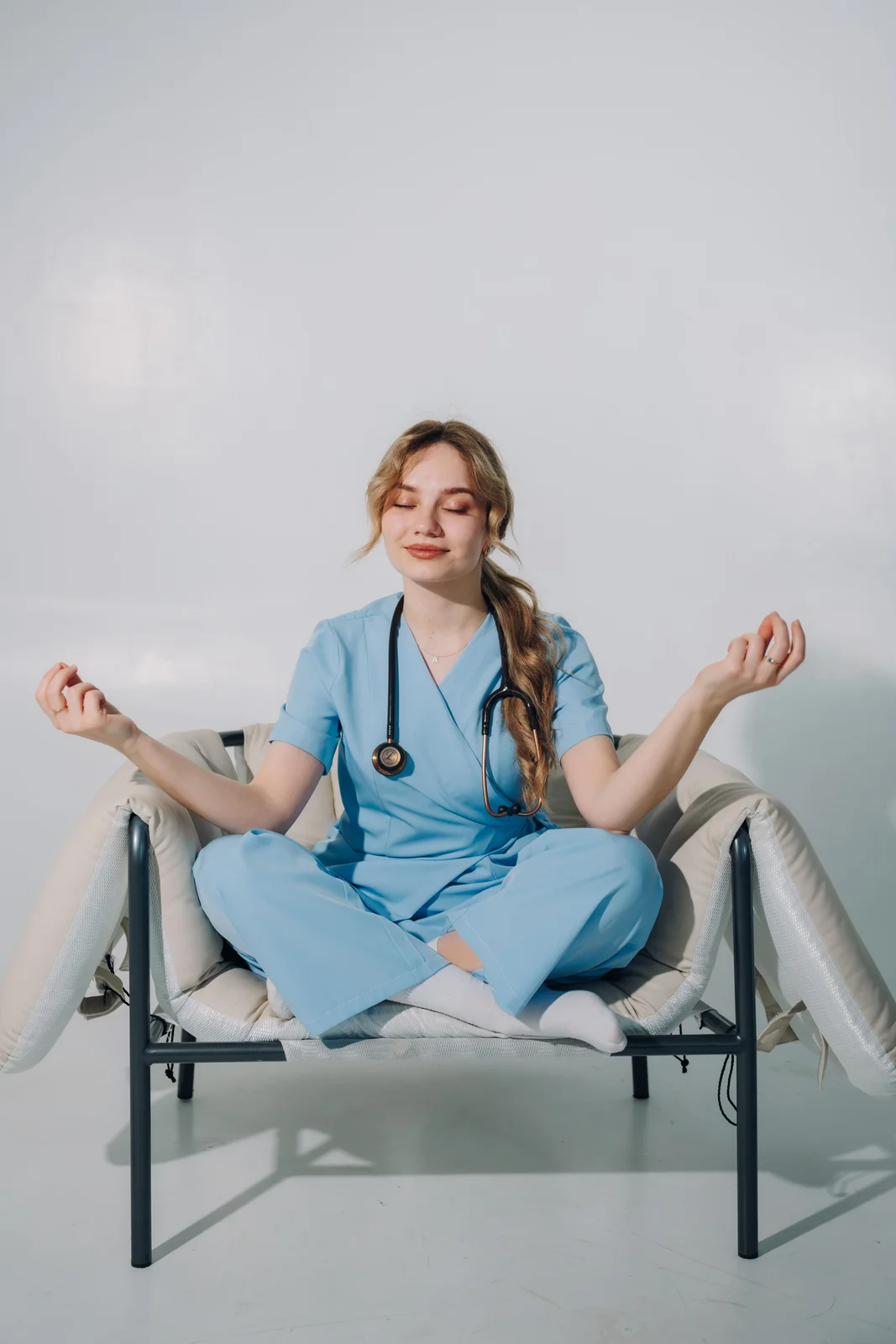 Verpleegkundige neemt in dienstkleding even rust met een korte meditatie